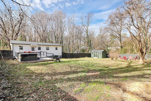 view of yard with a wooden deck, a storage shed, and a hot tub