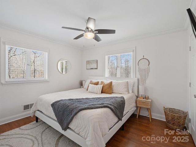 bedroom with crown molding, visible vents, ceiling fan, wood finished floors, and baseboards