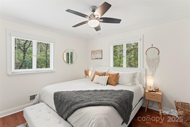 bedroom featuring baseboards, visible vents, dark wood-style flooring, and crown molding