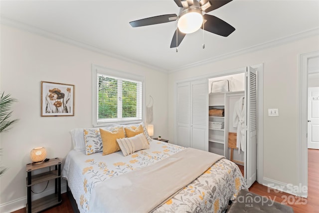 bedroom with baseboards, a closet, dark wood finished floors, and crown molding