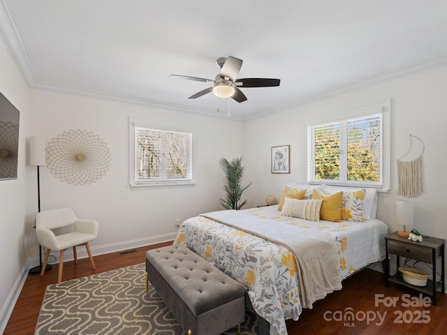 bedroom with baseboards, visible vents, a ceiling fan, ornamental molding, and wood finished floors