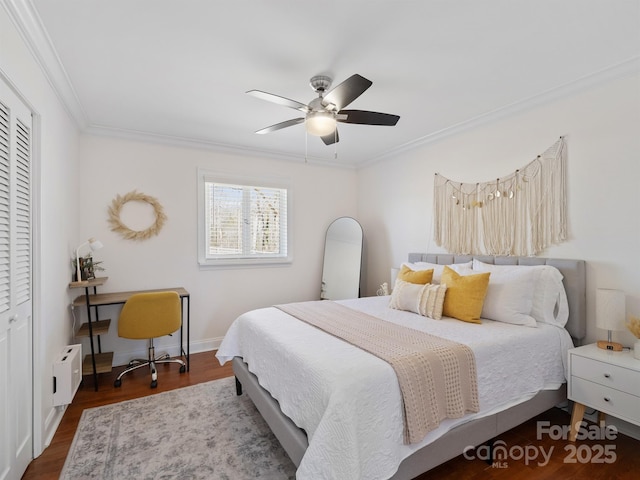 bedroom featuring a closet, ornamental molding, a ceiling fan, wood finished floors, and baseboards