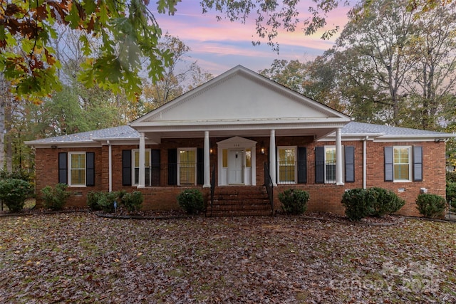 view of front of property featuring covered porch and brick siding