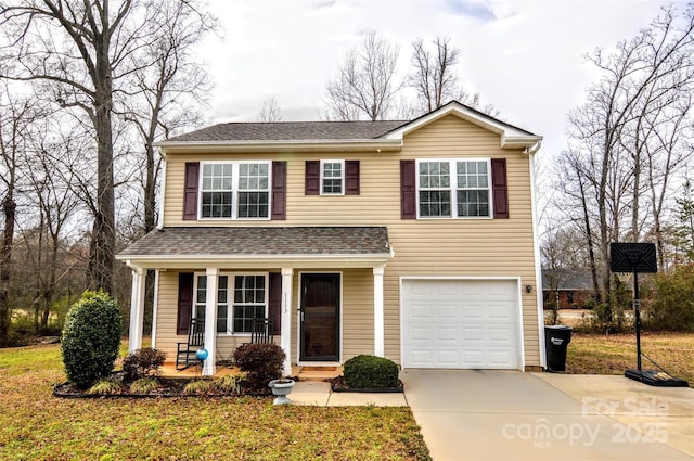 traditional home with an attached garage, covered porch, a shingled roof, concrete driveway, and a front yard