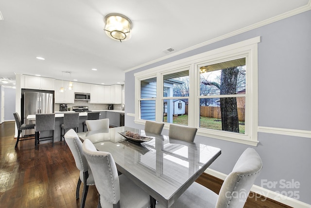 dining space with ornamental molding and dark hardwood / wood-style floors