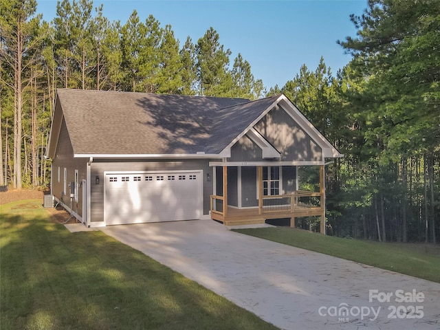 view of front of home with central AC unit, a garage, a front lawn, and covered porch