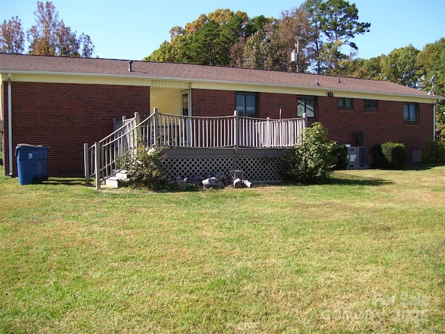 view of front of property featuring a deck, a front lawn, and central air condition unit