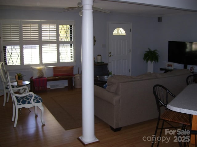 living room featuring crown molding, ceiling fan, hardwood / wood-style floors, and decorative columns