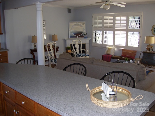 dining area featuring ceiling fan, ornamental molding, and ornate columns