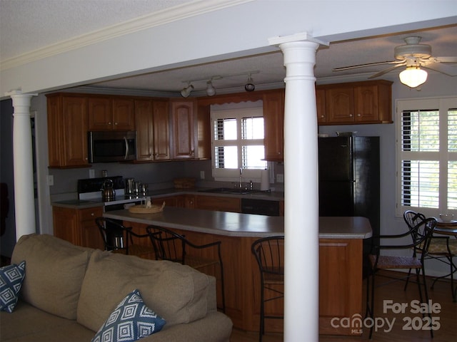 kitchen with black refrigerator, electric range oven, a wealth of natural light, and ornate columns