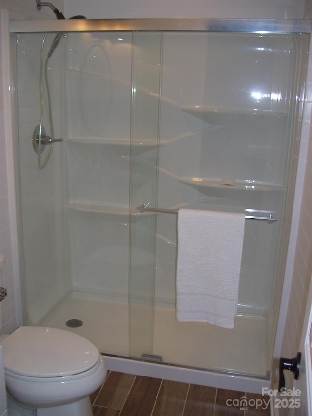 bathroom with toilet and an enclosed shower