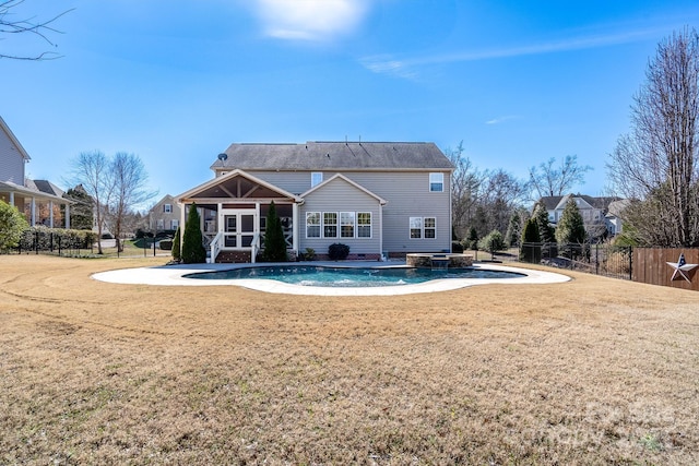 back of house featuring a fenced in pool and a yard