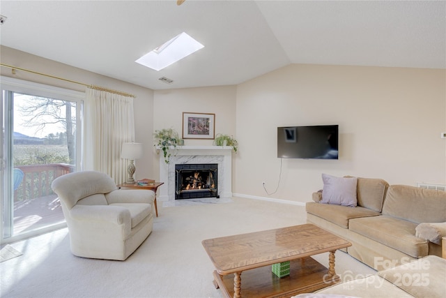 living room featuring a fireplace, vaulted ceiling with skylight, and carpet