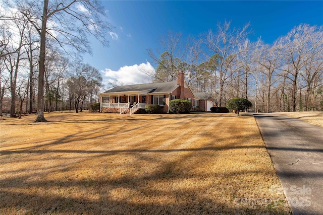 view of side of property featuring a porch and a lawn