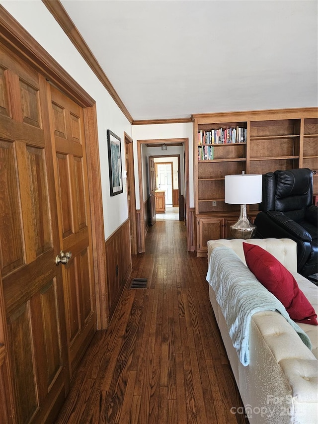 hallway featuring dark hardwood / wood-style flooring and crown molding