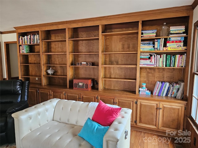 sitting room with crown molding and light hardwood / wood-style floors