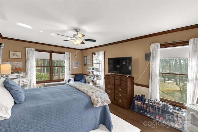 bedroom featuring ornamental molding, dark wood-type flooring, and ceiling fan