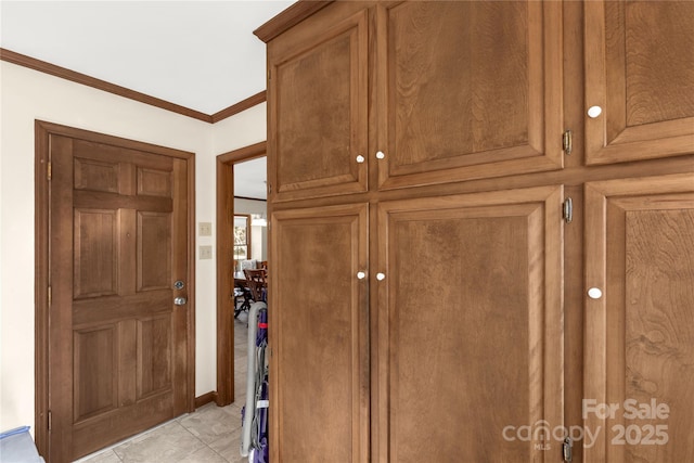 interior space featuring crown molding and light tile patterned flooring