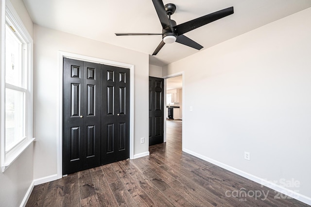 unfurnished bedroom with a closet, dark hardwood / wood-style floors, and ceiling fan