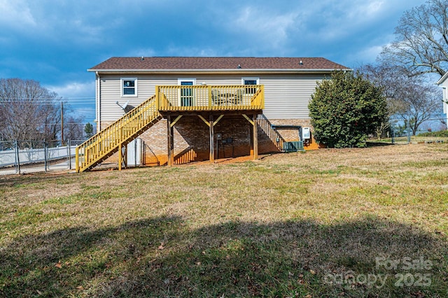 back of house featuring a wooden deck and a lawn