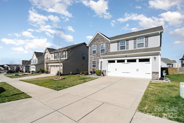 view of front of house featuring a front yard, stone siding, driveway, and an attached garage