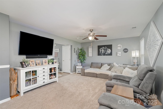 living room with light carpet, baseboards, visible vents, and a ceiling fan