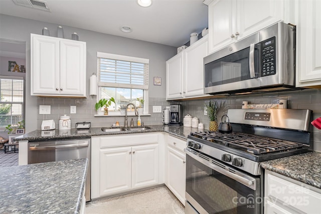 kitchen with appliances with stainless steel finishes, plenty of natural light, a sink, and visible vents