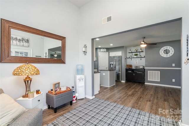 interior space with dark wood-type flooring, visible vents, baseboards, and a ceiling fan