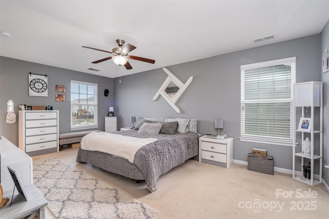 bedroom featuring a ceiling fan, light colored carpet, visible vents, and baseboards