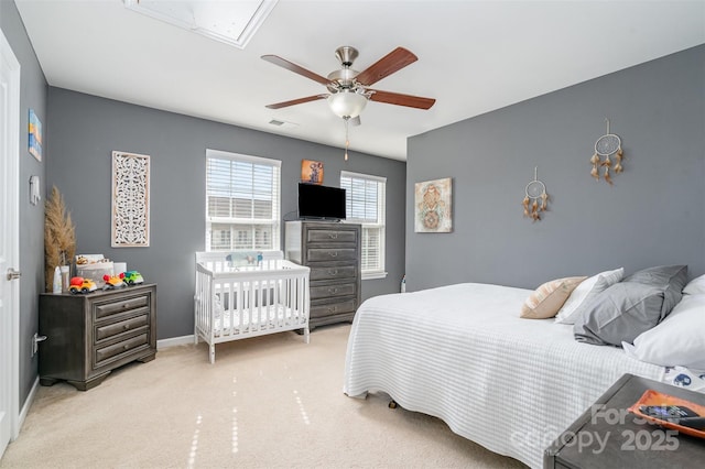 bedroom with carpet floors, visible vents, a ceiling fan, baseboards, and attic access