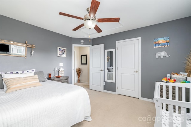 bedroom featuring light carpet, baseboards, and a ceiling fan