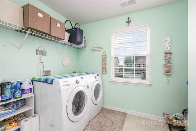 laundry area with washing machine and clothes dryer, visible vents, laundry area, baseboards, and tile patterned floors