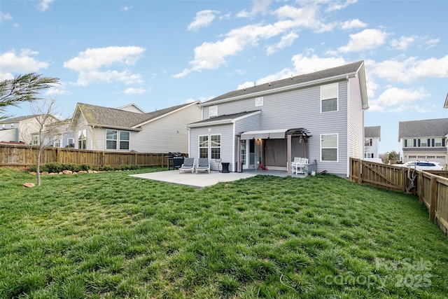 rear view of property featuring a lawn, a patio area, and a fenced backyard