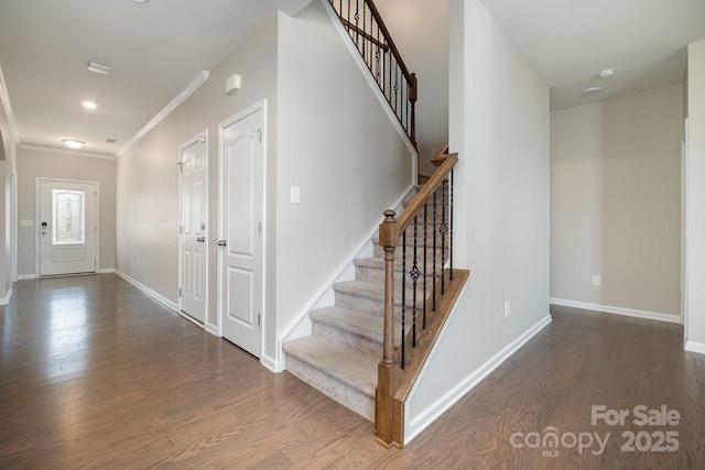 foyer entrance with dark wood-type flooring and ornamental molding