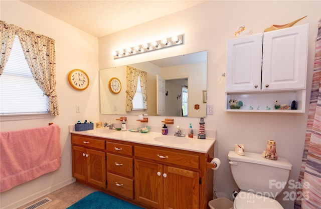 bathroom with vanity, a textured ceiling, and toilet