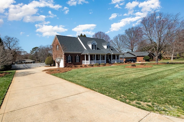 view of front of property with driveway, a garage, brick siding, a porch, and a front yard