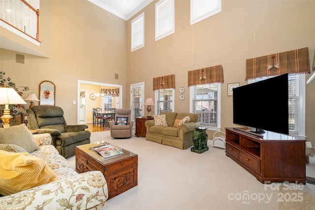 living area with carpet, visible vents, and crown molding