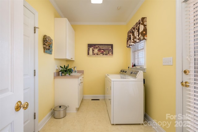 laundry room with baseboards, washing machine and dryer, cabinet space, and crown molding