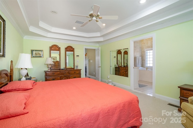 bedroom with carpet floors, a tray ceiling, visible vents, ornamental molding, and baseboards