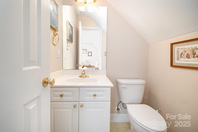 half bath with vaulted ceiling, vanity, and toilet