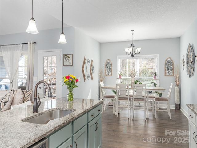 kitchen with hanging light fixtures, sink, a wealth of natural light, and dark hardwood / wood-style floors