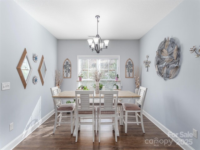 dining area with dark hardwood / wood-style flooring and a chandelier