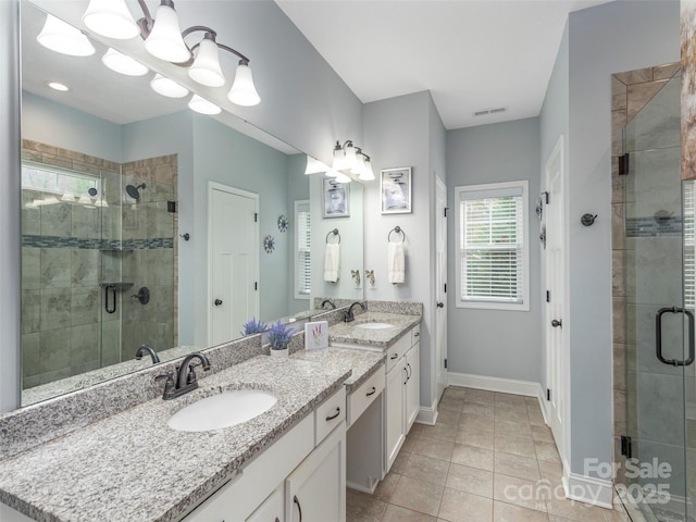 bathroom with tile patterned floors, vanity, and a shower with shower door