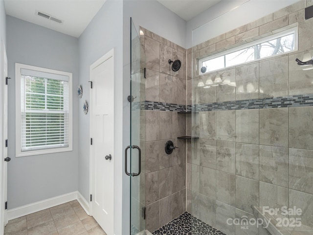 bathroom with an enclosed shower and tile patterned flooring
