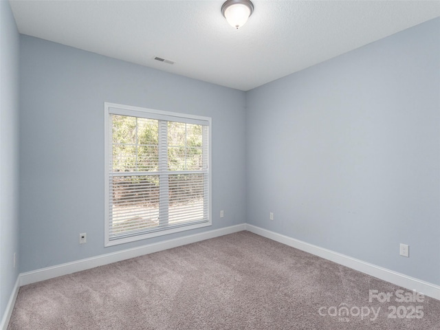 carpeted spare room featuring a textured ceiling
