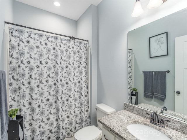 bathroom featuring vanity, a shower with shower curtain, and toilet