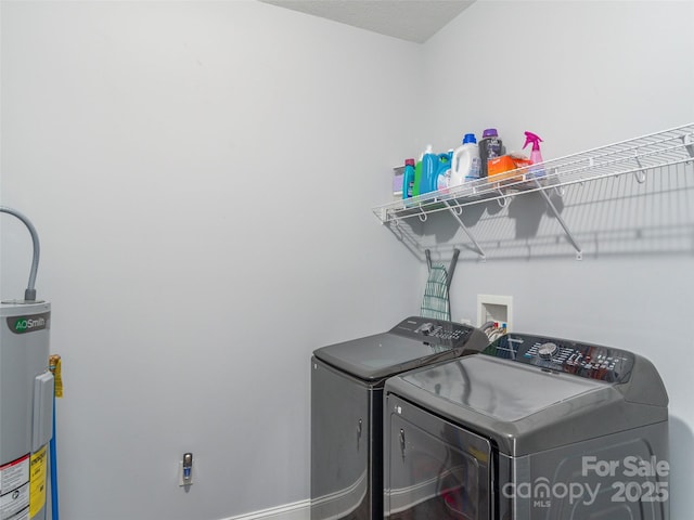 clothes washing area featuring electric water heater and washing machine and clothes dryer
