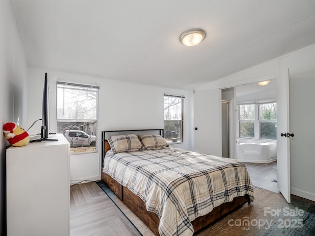 bedroom with parquet flooring and vaulted ceiling