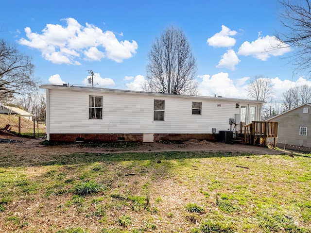 back of house featuring central AC and a lawn