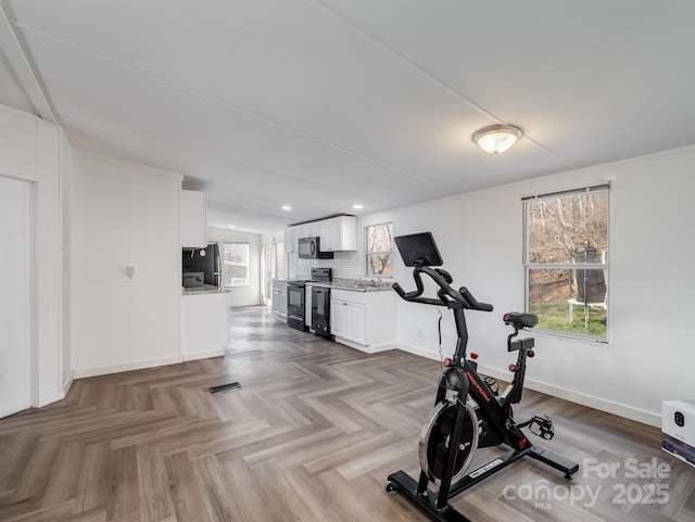 exercise area with a wealth of natural light and dark parquet floors